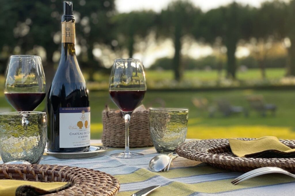 Bouteille et verres de vin de Cahors sur une table au Domaine de Labarthe